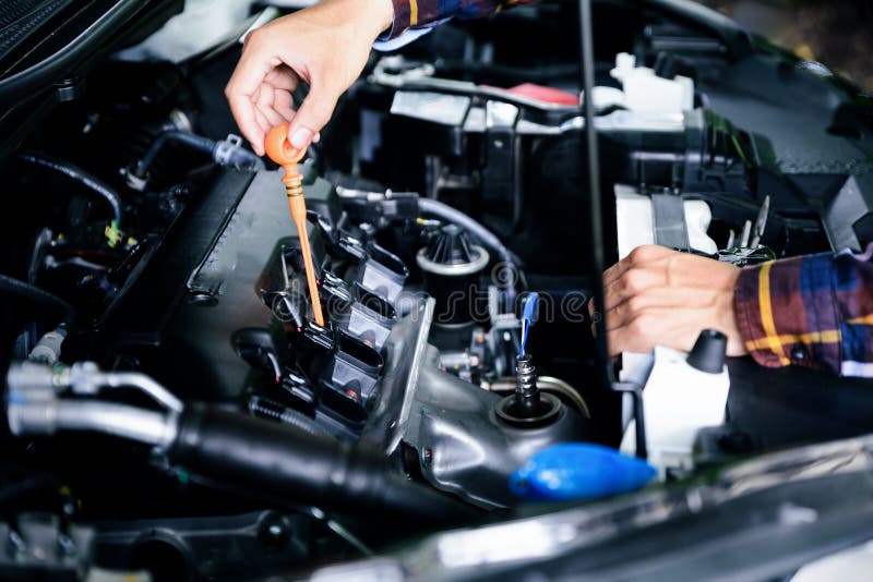 Schließen Sie herauf die Hände, die Schmierölölstand des Automotors von tiefem-s überprüfen stockbild Schließen Sie herauf die Hände, die Schmierölölstand des Automotors von tiefem-s überprüfen stockbild