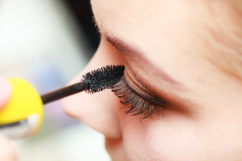 Schließen Sie herauf Frau, die das Erhalten bilden, Wimperntusche stockfoto