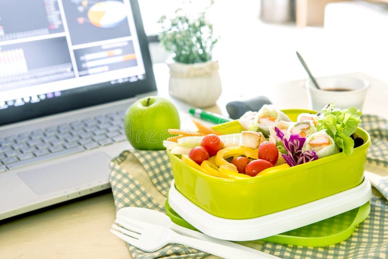 Close up green Lunch box on work place of working desk ,Healthy eating clean food habits for diet and health care concept. Close up green Lunch box on work place of working desk ,Healthy eating clean food habits for diet and health care concept