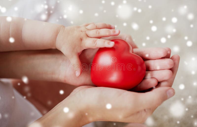 Schließen Sie oben von den Baby- und Mutterhänden mit rotem Herzen lizenzfreie stockfotos Schließen Sie oben von den Baby- und Mutterhänden mit rotem Herzen lizenzfreie stockfotos