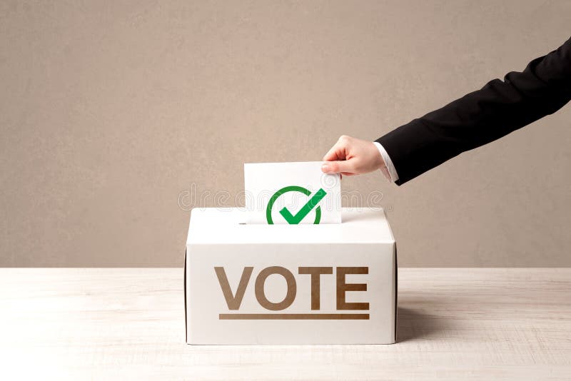 Schließen Sie oben von der männlichen Hand, die Abstimmung in eine Wahlurne setzt lizenzfreies stockbild Schließen Sie oben von der männlichen Hand, die Abstimmung in eine Wahlurne setzt lizenzfreies stockbild
