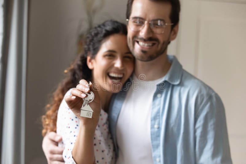 Close up portrait blurred background of excited Caucasian couple renters show house keys moving together. Overjoyed men and women family tenants happy buying first shared home. Realty concept. Close up portrait blurred background of excited Caucasian couple renters show house keys moving together. Overjoyed men and women family tenants happy buying first shared home. Realty concept.