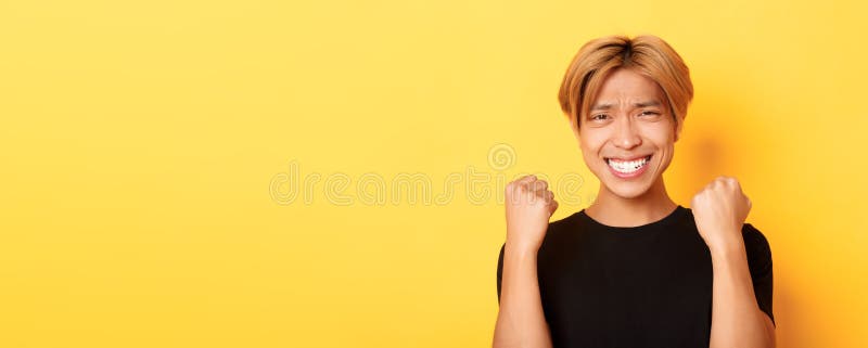 Schließung des glücklichen asiatischen Jungs, der den Preis gewann, indem er die erste Pumpe-Geste machte und das Lächeln zufriede lizenzfreies stockbild
