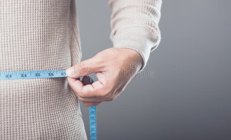 Schließung von jemandem, der ein blaues Messband verwendet, um ihre Taille oder Hüften zu messen, symbolisiert das Konzept der Erh lizenzfreie stockbilder