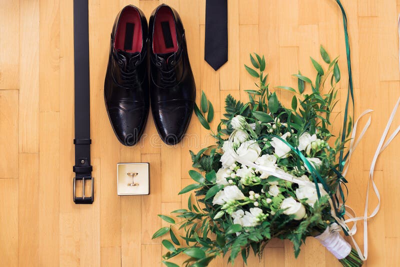 Schließung von Männerzubehör auf Holzboden Obere Sicht auf Gürtel, Schuhe, Blumenkorsage, goldene Ringe, Hochzeitskonzept lizenzfreie stockfotografie Schließung von Männerzubehör auf Holzboden Obere Sicht auf Gürtel, Schuhe, Blumenkorsage, goldene Ringe, Hochzeitskonzept lizenzfreie stockfotografie