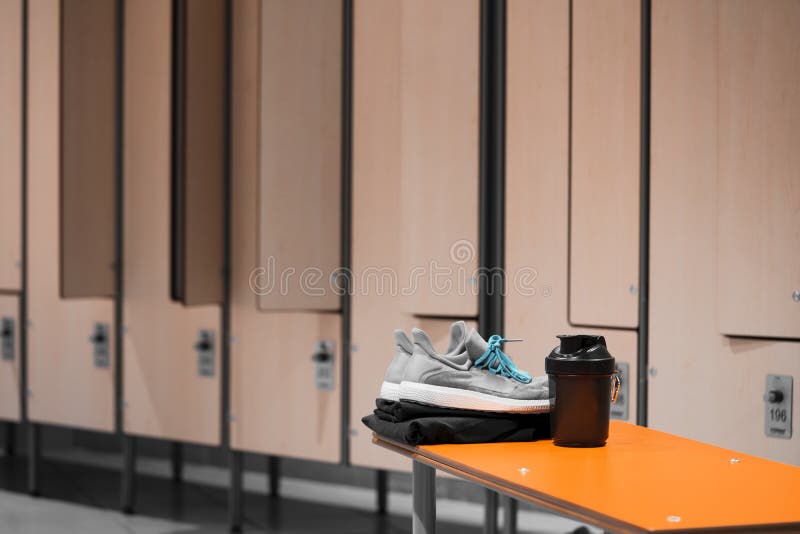 Schließen Sie oben von der Sportschuh-, -sportkleidungs- und Sport-wasserflasche im Turnhallenumkleideraum stockfotografie Schließen Sie oben von der Sportschuh-, -sportkleidungs- und Sport-wasserflasche im Turnhallenumkleideraum stockfotografie