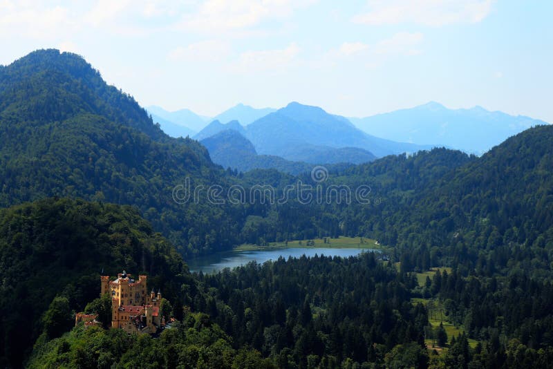 Schloss Hohenschwangau, os cumes e Alpsee em Alemanha imagem de stock Schloss Hohenschwangau, os cumes e Alpsee em Alemanha imagem de stock