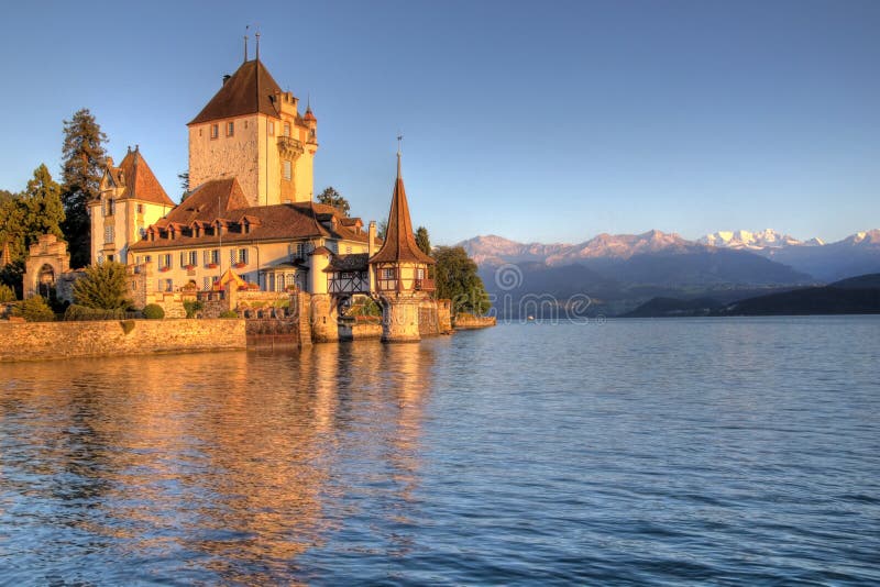 Posledné lúče slnka na romantické Oberhofen Hrad (Schloss) na okraji Jazera Thun v centrálnom Švajčiarsku.