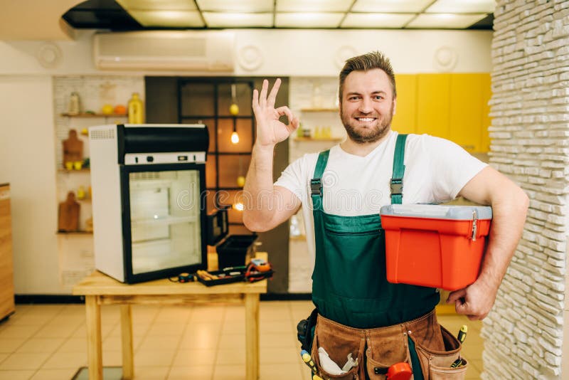 Schlosser in der Uniform hält Werkzeugkasten, Heimwerker lizenzfreies stockbild Schlosser in der Uniform hält Werkzeugkasten, Heimwerker lizenzfreies stockbild