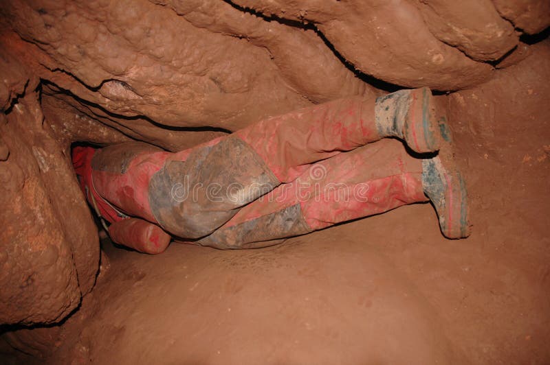 Narrow cave passage with caver in a extreme situation. Narrow cave passage with caver in a extreme situation