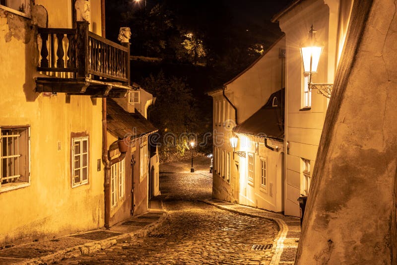 Schmale Pflasterstraße in der alten mittelalterlichen Stadt mit belichteten Häusern durch WeinleseStraßenlaternen, Novy-svet, Pra stockbilder Schmale Pflasterstraße in der alten mittelalterlichen Stadt mit belichteten Häusern durch WeinleseStraßenlaternen, Novy-svet, Pra stockbilder