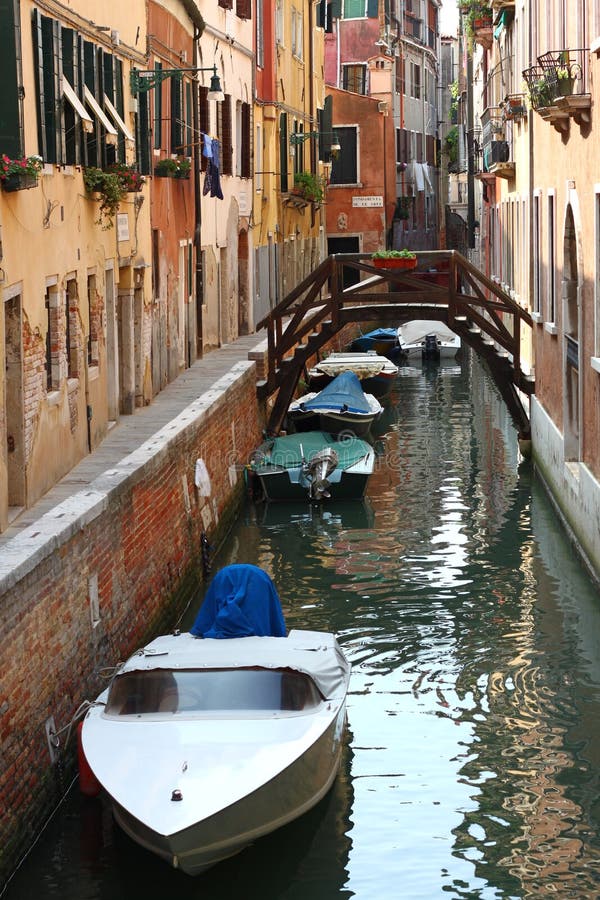 Schmaler Kanal mit Brücke und Booten in Venedig stockbild Schmaler Kanal mit Brücke und Booten in Venedig stockbild