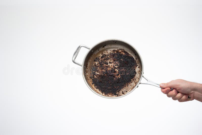 Dirty oily burnt metal frying pan held in hand by male hand. Dirty oily burnt metal frying pan held in hand by male hand.