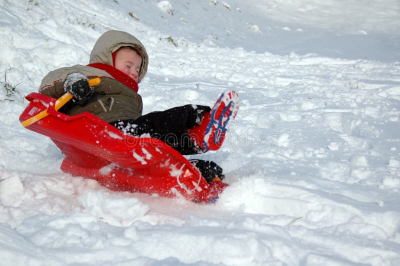 Small boy (3) on a sleigh sliding down a snowy hill. Small boy (3) on a sleigh sliding down a snowy hill.