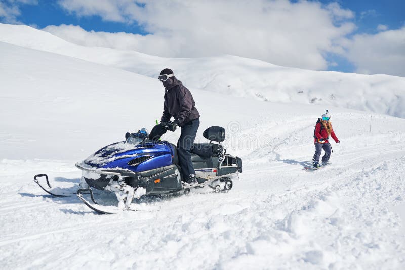 Schneemobil fahrung schleppt Mädchensnowboarder stockbilder Schneemobil fahrung schleppt Mädchensnowboarder stockbilder