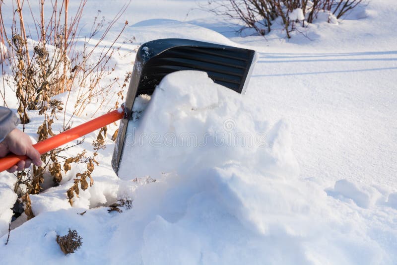 Schneeräumung durch Schaufel nach Schneefällen draußen lizenzfreie stockbilder Schneeräumung durch Schaufel nach Schneefällen draußen lizenzfreie stockbilder