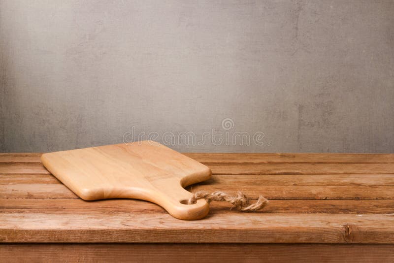 Schneidebrett auf hölzerner Plattformtabelle über rustikalem Wandhintergrund kochen lizenzfreie stockfotografie Schneidebrett auf hölzerner Plattformtabelle über rustikalem Wandhintergrund kochen lizenzfreie stockfotografie