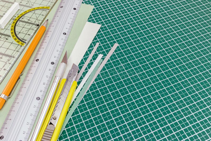 Schneidematte mit Gebrauchsmesser, mechanischer Bleistift, Metallmachthaber a lizenzfreie stockfotos Schneidematte mit Gebrauchsmesser, mechanischer Bleistift, Metallmachthaber a lizenzfreie stockfotos