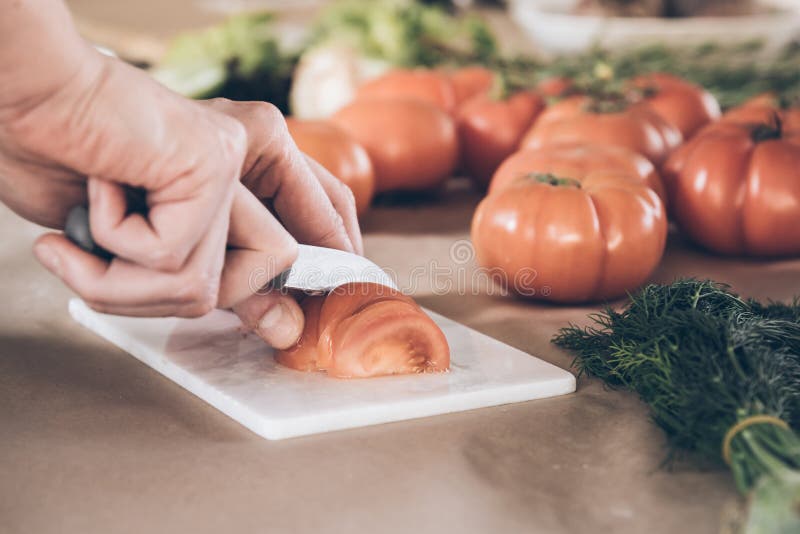 Schneiden von frischen Tomaten auf Schneidebrett lizenzfreie stockfotos Schneiden von frischen Tomaten auf Schneidebrett lizenzfreie stockfotos