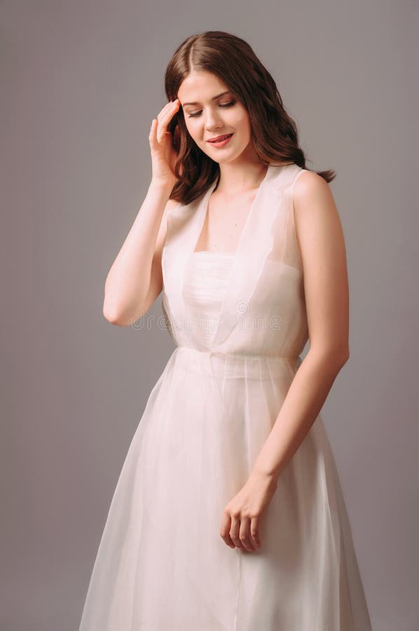 Schnelles Hochzeitskleid in Weiß mit klarem Kap. Touchstudio Portrait von schönen fröhlichen Brunette Braut lizenzfreies stockbild