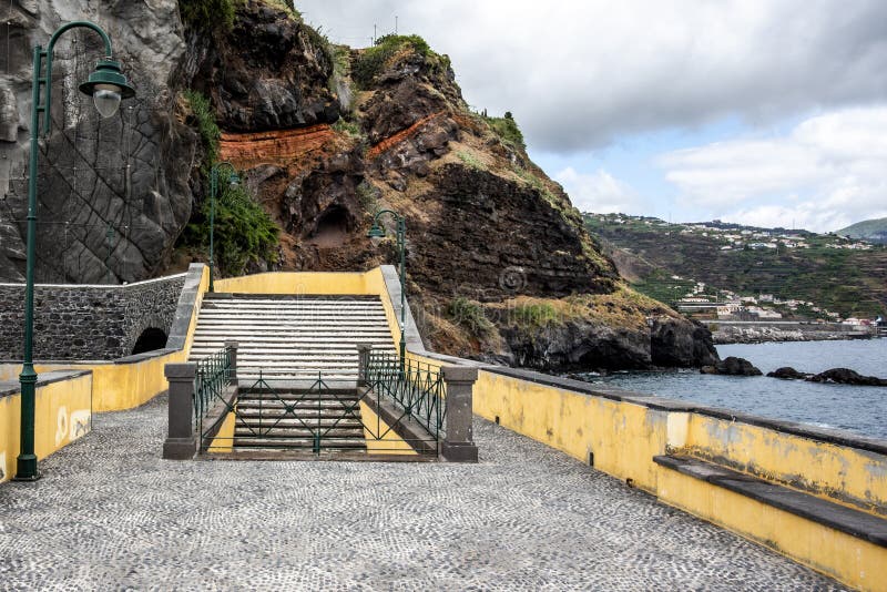 Stairway on the raised pontoon between the lava rocks of the port of Ponta do Sol on the Atlantic ocean in Madeira Portugal. Stairway on the raised pontoon between the lava rocks of the port of Ponta do Sol on the Atlantic ocean in Madeira Portugal