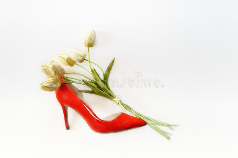 Schoen van de dames de rode hoge die hiel met van het boeket witte tulpen en exemplaar ruimte op witte achtergrond wordt gevuld V royalty-vrije stock fotografie Schoen van de dames de rode hoge die hiel met van het boeket witte tulpen en exemplaar ruimte op witte achtergrond wordt gevuld V royalty-vrije stock fotografie