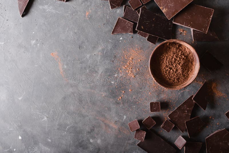 Schokoladenklumpen und Kakaopulver Schokoriegel-Stücke Eine große Schokolade auf grauem abstraktem Hintergrund