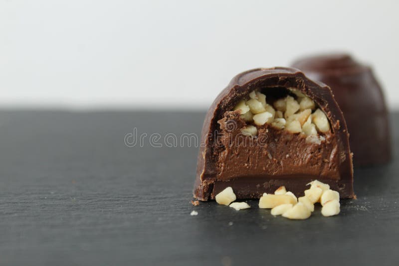 Schokoladenkuchen mit Pralinganache und Erdnüssen auf grauem schwarzem Hintergrund. Schokoladentag stockbilder