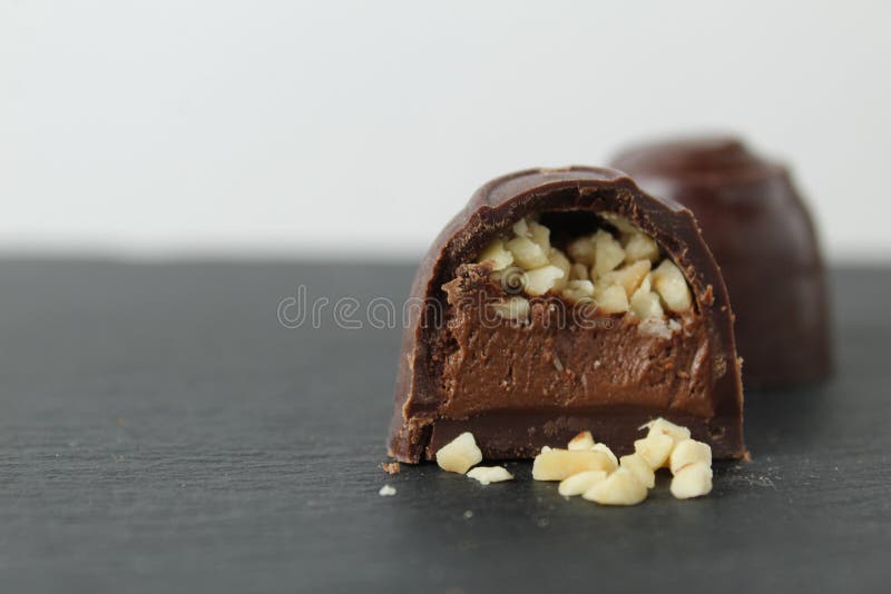 Schokoladenkuchen mit Pralinganache und Erdnüssen auf grauem schwarzem Hintergrund. Schokoladentag stockfotografie