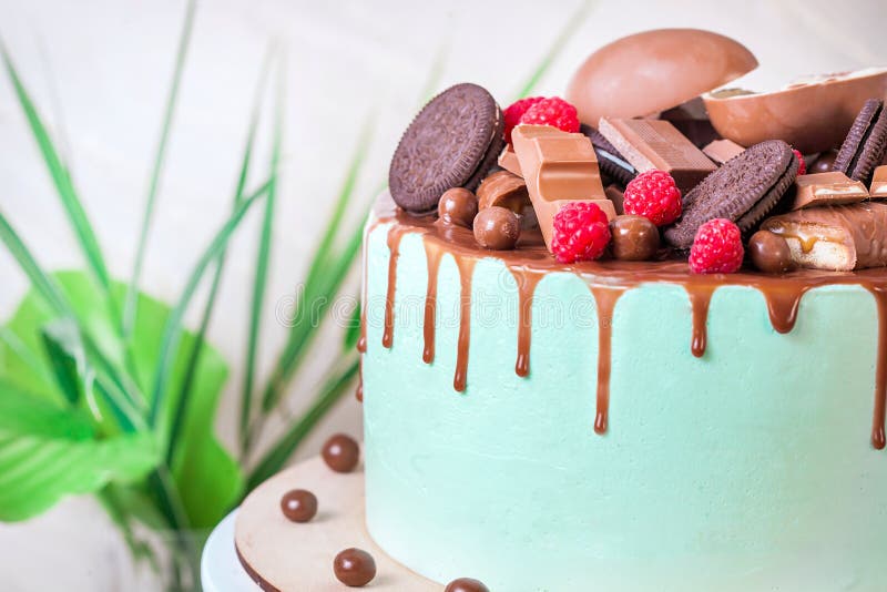 Schokoladenkuchen mit süßen Himbeeren und Süßigkeiten mit tadelloser Glasur auf weißem hölzernem Stand Abschluss oben lizenzfreie stockbilder Schokoladenkuchen mit süßen Himbeeren und Süßigkeiten mit tadelloser Glasur auf weißem hölzernem Stand Abschluss oben lizenzfreie stockbilder