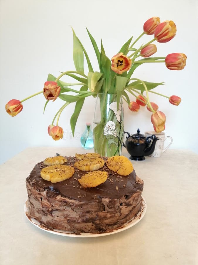 Schokoladenkuchen verziert mit Orangen auf dem Hintergrund von Tulpen lizenzfreie stockfotos Schokoladenkuchen verziert mit Orangen auf dem Hintergrund von Tulpen lizenzfreie stockfotos