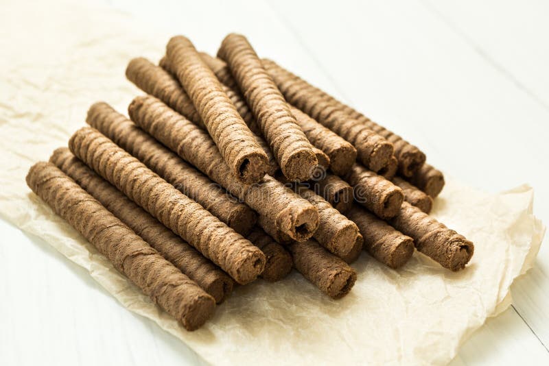 Schokoladenoblate rollt auf einem hölzernen Hintergrund lizenzfreie stockfotografie Schokoladenoblate rollt auf einem hölzernen Hintergrund lizenzfreie stockfotografie