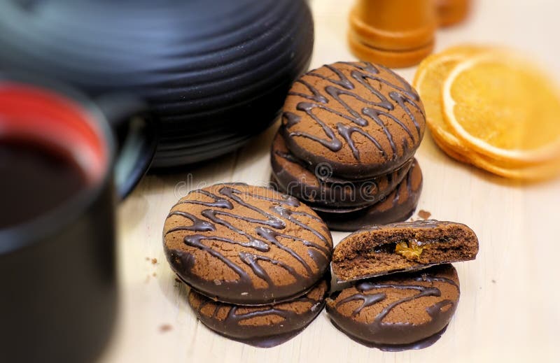 Schokoladenplätzchen und Geräte des schwarzen Tees Schale und Teekanne Getrocknete orange Scheiben Teeszene