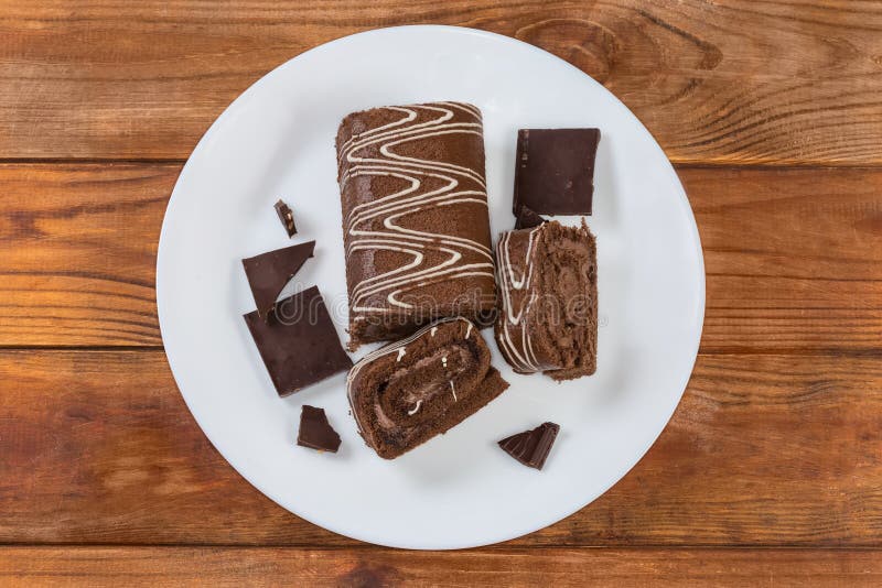Schokoladenrolle, teilweise geschnitten, dunkle Schokolade auf der obersten Schüssel mit Blick auf die Schokolade
