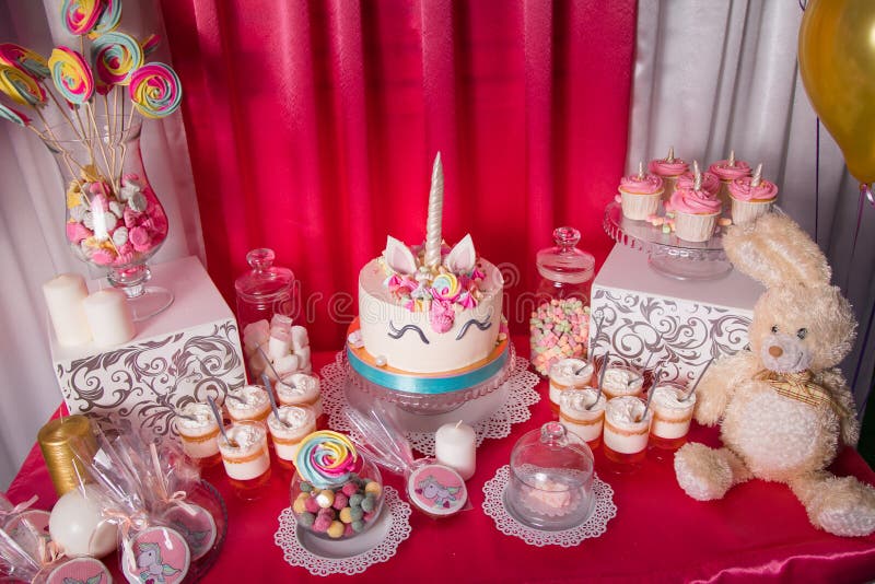 Schokoriegel für den ersten Geburtstag für kleines Baby Süße Tabelle und großer Einhornkuchen lizenzfreies stockfoto Schokoriegel für den ersten Geburtstag für kleines Baby Süße Tabelle und großer Einhornkuchen lizenzfreies stockfoto
