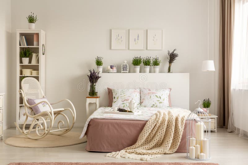 Schommelstoel naast bed met deken in provencal slaapkamerbinnenland met installaties en affiches Echte foto royalty-vrije stock foto Schommelstoel naast bed met deken in provencal slaapkamerbinnenland met installaties en affiches Echte foto royalty-vrije stock foto