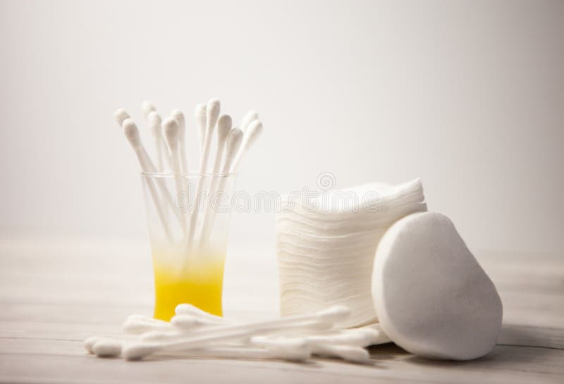 Schone katoenen stootkussens en stokken in een glas voor het lichaam op een lichte achtergrond, het concept zorg gezichts stock afbeeldingen Schone katoenen stootkussens en stokken in een glas voor het lichaam op een lichte achtergrond, het concept zorg gezichts stock afbeeldingen