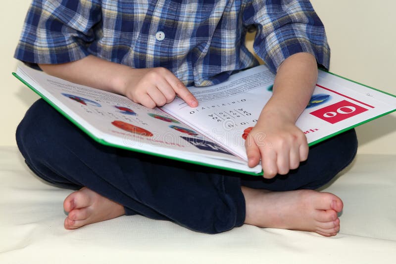 Pequeno chico lo intenta sobre el leer el primero un libro.