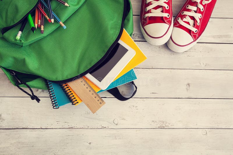 School backpack on wooden background royalty free stock photo