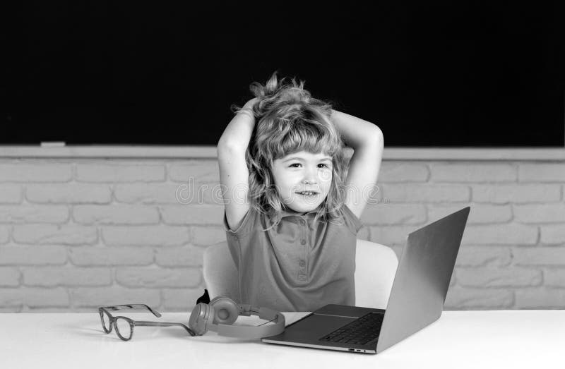 School boy learn lesson sitting at desk, studying online e-learning use internet. Education and knowledge modern royalty free stock photos