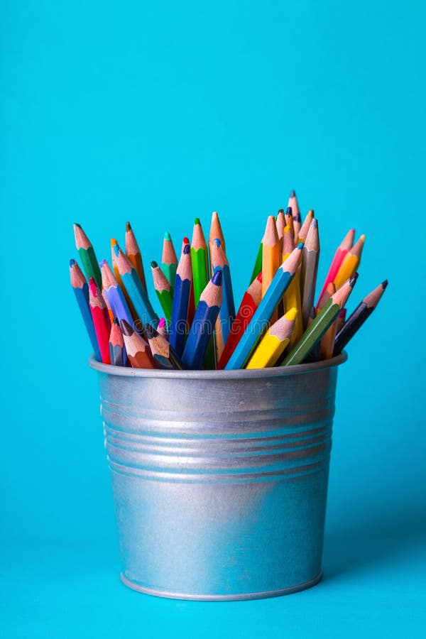 Bucket with pencils on a blue background