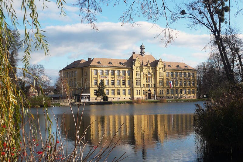 School building in the mirror of pond in Litovel, Czech Republic