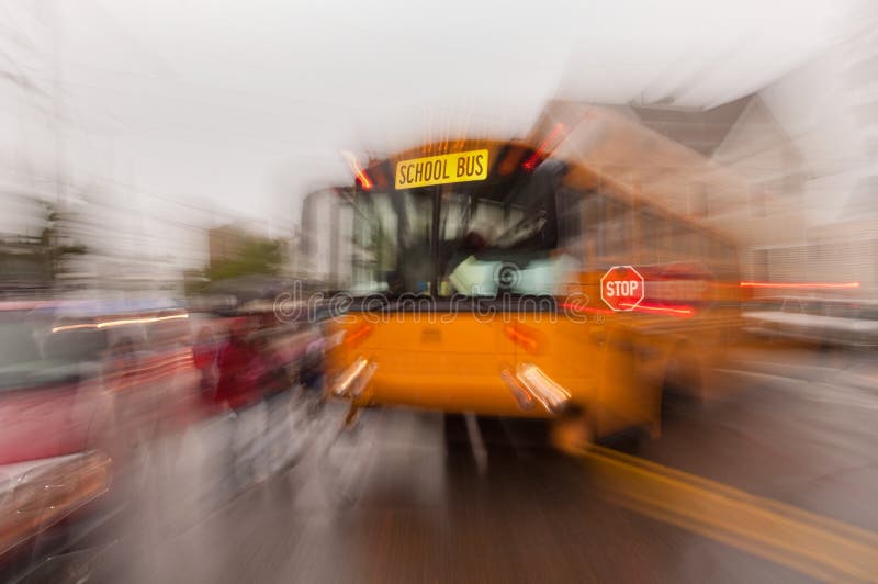 A school bus driver stops to pick up a group of children in this expressive motion photograph. A school bus driver stops to pick up a group of children in this expressive motion photograph.