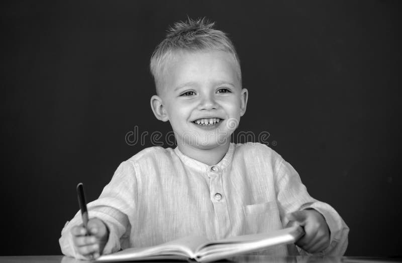 School child student learn lesson sitting at desk studying. Kid writing in notebook in class. Education and kids royalty free stock photos