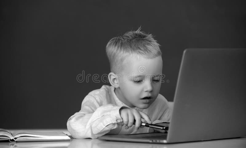 School child using digital pc laptop in class. Portrait of funny pupil of primary school study programming. Funny blonde royalty free stock images
