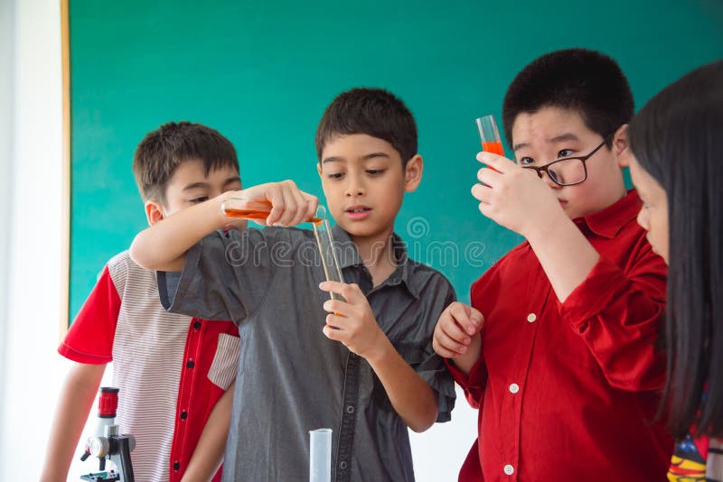 School children doing chemistry experiment in classroom royalty free stock images