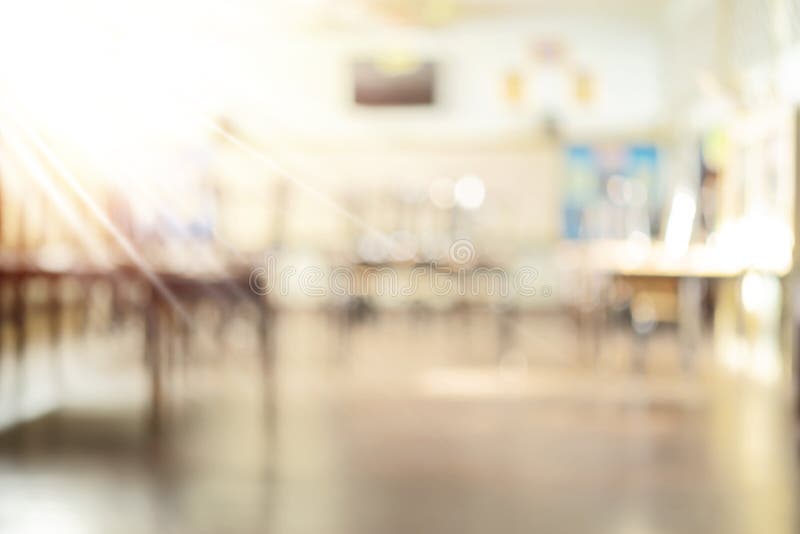 School classroom in blur background without young student; Blurry view of elementary class room no kid or teacher with chairs and tables in campus