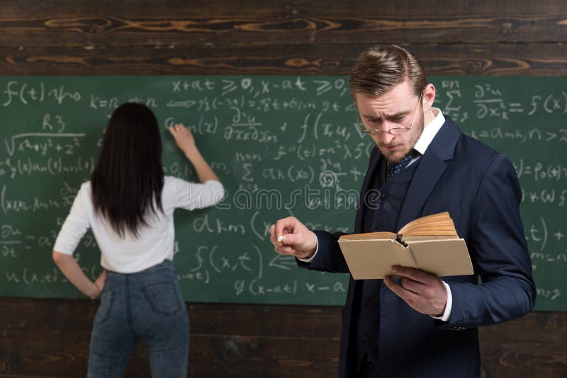 School day. Teacher man in glasses read problem statement from textbook to girl student. Learning math enables me to.