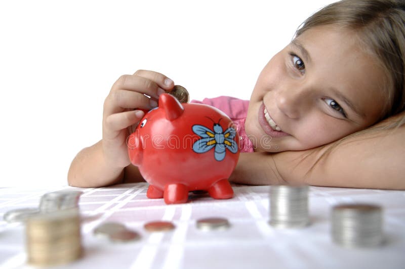 School girl count coins before dropping them into the piggy bank. School girl count coins before dropping them into the piggy bank.