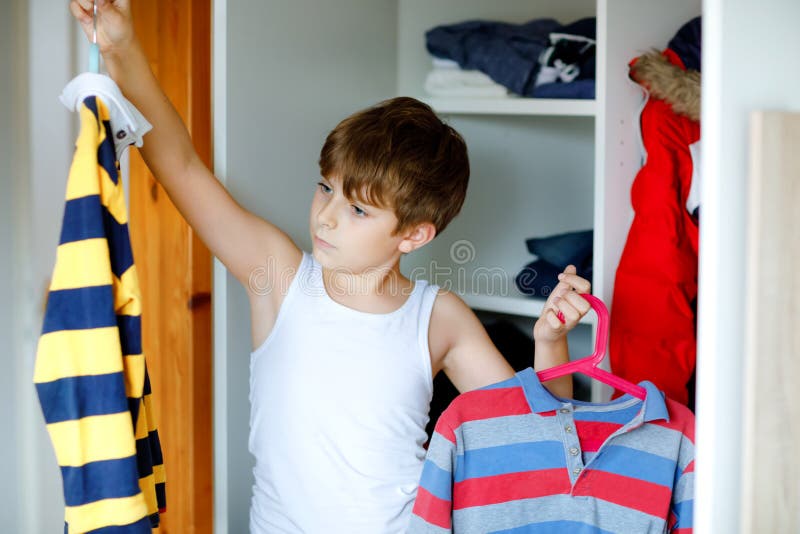 School Kid Boy Standing by Wardrobe with Clothes. Child Making Decision ...